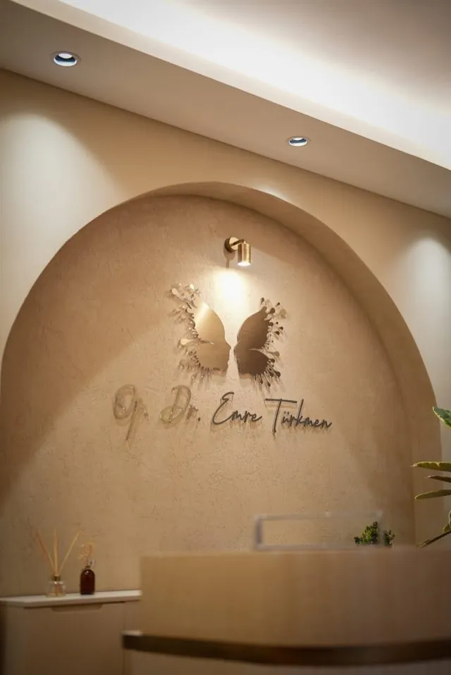Gold butterfly and Op. Dr. Emre Türkmen signature in the arched niche